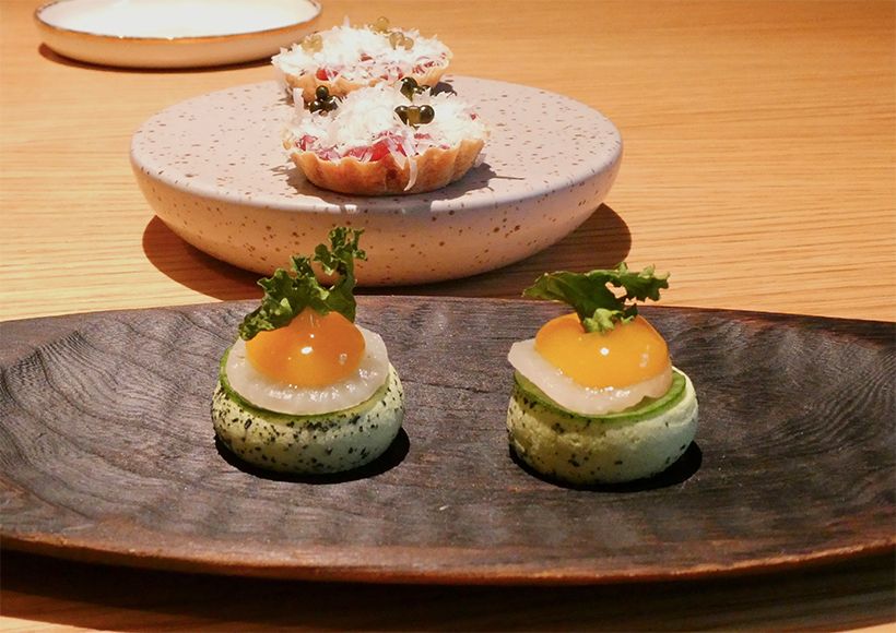 手でつまんでいただく、一口大のアミューズ。手前は「大根とシーバックソーンのジュレ」。グリーンのメレンゲの上に大根のマリネと、栄養豊富なオレンジ色の実のシーバックソーンのジュレが重なり、トップにケールの葉を。後ろは「鹿肉タルタルのタルトレット」。