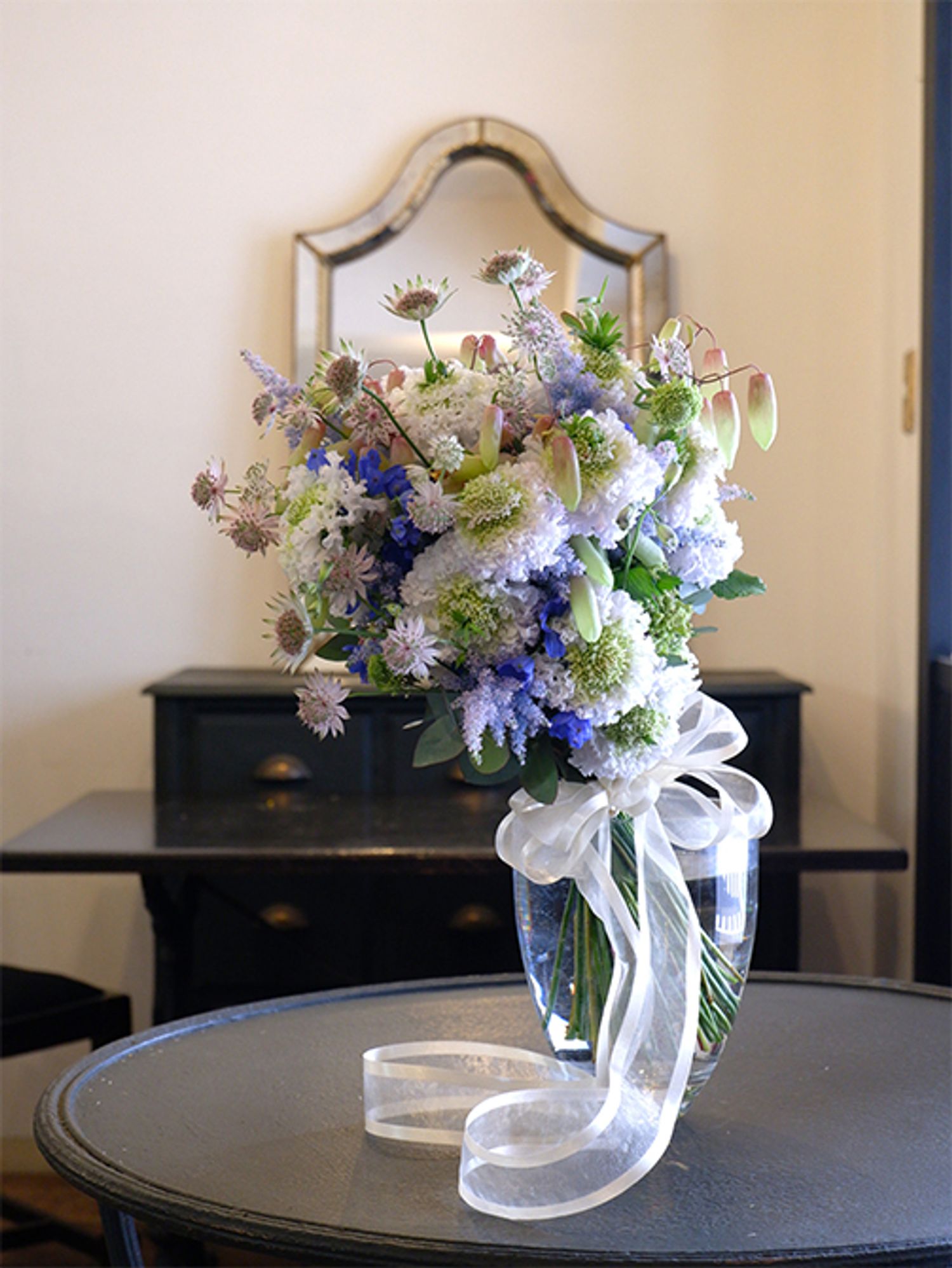 フリフリスカビオサの‘スイ’を主役にしたウエディングブーケを制作しました。じつは2月に、寺尾さんご夫妻が大阪の花市場に行った帰りに、広島の私の店に寄ってくださいました。ご親戚の結婚式で花嫁さんに贈るブーケを手作りしたいということで、サンプルとして作ったブーケです。フリンジの入ったもこもこのスカビオサは、ボリューム感があります。ほかに、アストランティア‘フローレンス’、デルフィニウム‘スーパーグランブルー’、カランコエ‘グリーンアップル’、染めのアスチルベ‘ライトブルー’などを使用。