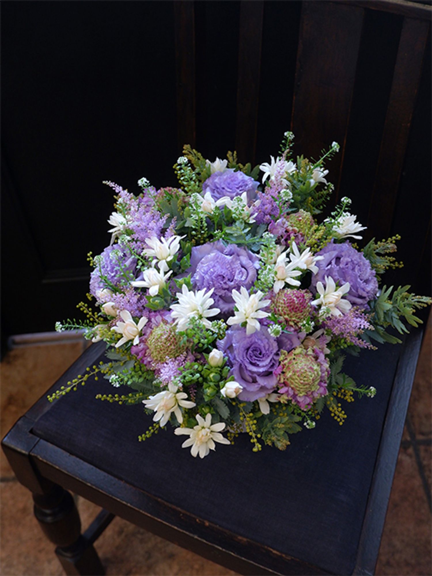 スカビオサ‘ヒマリ’に薄紫の花を合わせ、シックで上品なアレンジに。薄紫はリシアンサス‘NFラベンダー’と染めのアスチルベ‘ラベンダー’。小さな白いカーネーションの‘ミニティア ミルク’を散らして明るさをプラス。タラスピオファリムと銀葉アカシアをあしらいに加えました。スカビオサ‘ヒマリ’の花心の色がナチュラル感を出してくれます。