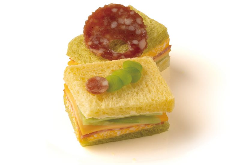 ほうれん草とにんじんをそれぞれ練 り込んだパンに、卵やサラミをサン ド。サラミを食べて穴をあけたあお むしが、手前のサンドイッチにいる のもシェフのこだわりポイント。