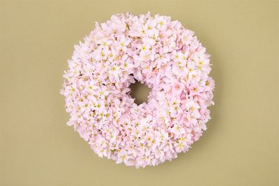 ヒガンザクラとケイオウザクラの２種のサクラだけを贅沢に使った、「満開の桜」という春の景色を表現したリース。淡いピンクのケイオウザクラを基調に、バランスを見ながら白にほど近いヒガンザクラを散らし、色合いの異なる花を組み合わせ、咲き乱れる様を演出しています。