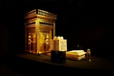 防腐処理された王の内臓が納められていたカノプス厨子とカノプス人型棺容器。守護を願ったヒエログリフが刻まれ、周囲を女神が守っている。／©ツタンカーメン・ミュージアム 