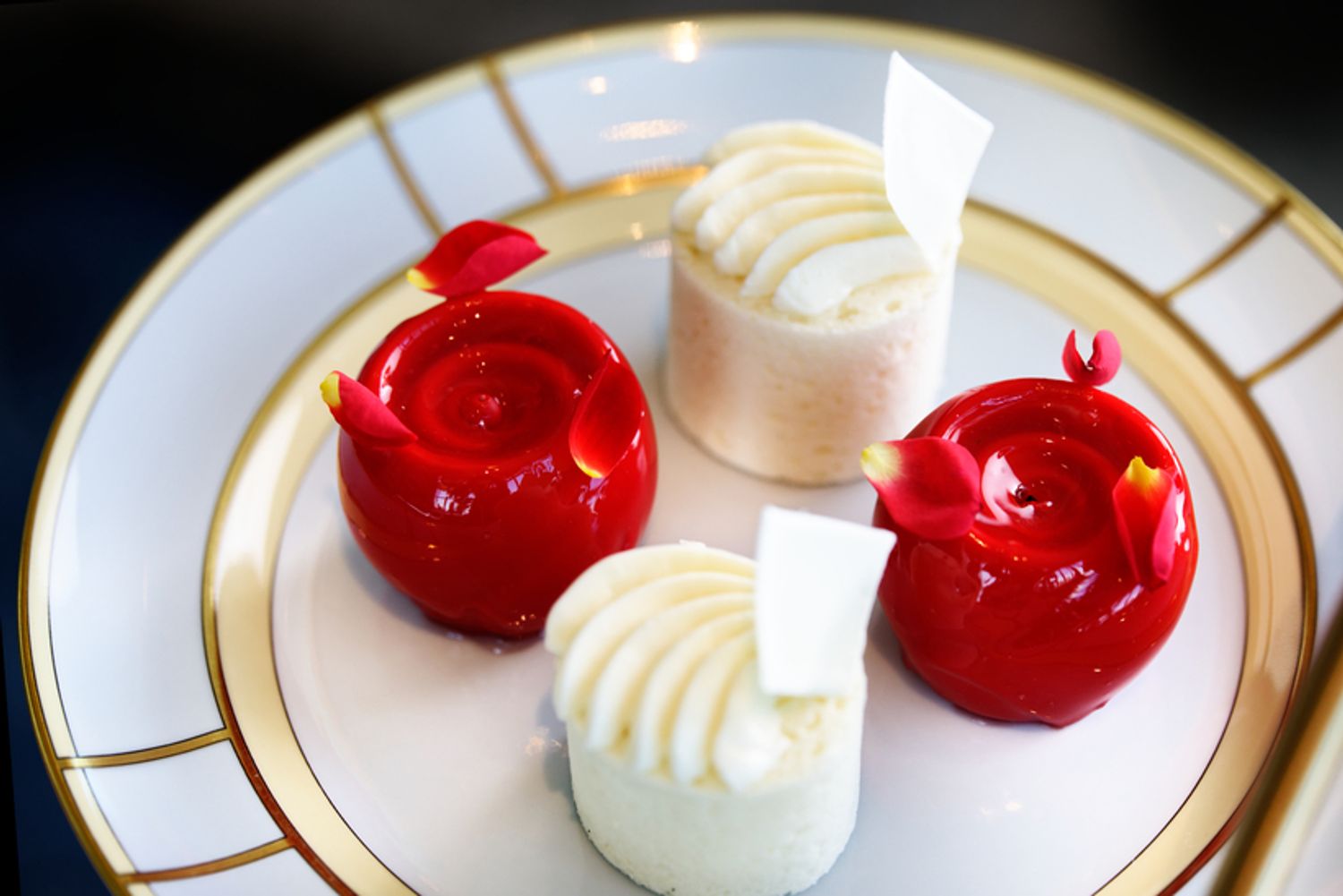 「ベルベットチーズケーキ　ローズ」（写真左右）は、「ウォルドーフ・アストリア・ニューヨーク」で長く愛されてきたシグネチャーをアレンジしたひと品。1周年を記念し華やかなバラの形に再構築。チョコレートコーティングを割ると、ほどよい酸味のチーズソースが溢れ出す。