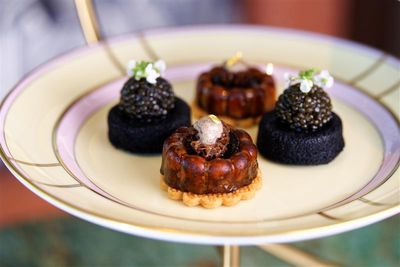 セイボリーの「竹炭のフィナンシェとWAオリジナルキャビア　サワークリーム添え」（写真左右）はファンの多い定番メニュー。キャビアの濃厚な旨みと、カルピスバターの穏やかな塩味が利いたフィナンシェが溶け合う。