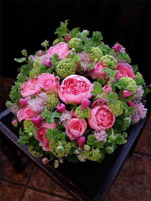 ご両親から娘さんへ、結婚祝いの贈り花を。ピンクとフレッシュグリーンの花色合わせで、かわいらしいながらもパッと目立つアレンジを制作しました。この時期に出回るシャクヤクのボリューム感と、セアノサス‘マリーサイモン’の繊細さ。これはとても相性のよい組み合わせだと感じます。シャクヤクは‘エッチドサーモン’を使用。ほかにバラ‘ブロッサムピンク’、クレマチス‘天使の首飾り’を合わせ、濃淡ピンクの花色合わせにしました。みずみずしい緑色は、ビターチョコゼラニウムとビバーナム・スノーボールです。