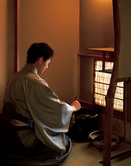小間・成趣庵（じょうしゅあん）にて、風炉の灰形をつくる若宗匠。暑さに向かいはじめる初風炉の季節は、素焼きの陶器に黒漆を塗って磨き上げた「真の土風炉（どぶろ）」を用いる。五徳の手前の綺麗な“一文字”は、遠州流茶道ならでは。右手には“湿し灰”が入った焙烙（ほうろく）が。