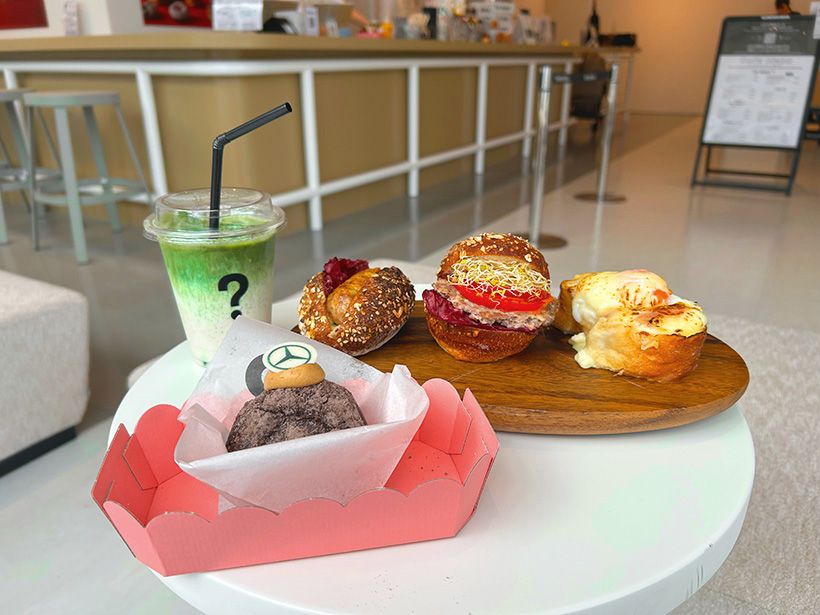 I'm donut?の生ドーナツ。ベンツのエンブレムがあしらわれたキャラメルエスプレッソ（左下）の他、ダコードッグ(中央左),、クロックマダム(右)など"おかず系"ドーナツも充実する。