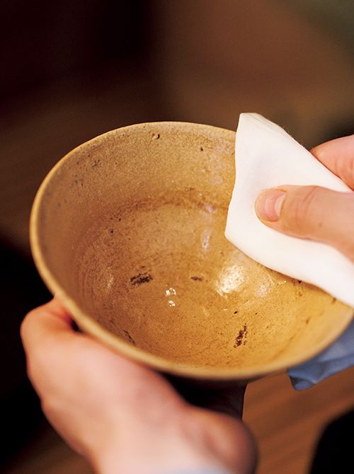 茶碗を浄める様子。茶碗を水洗いした後、茶巾で縁を挟み、茶碗を回しながら、ぐるりと1周拭き上げる。