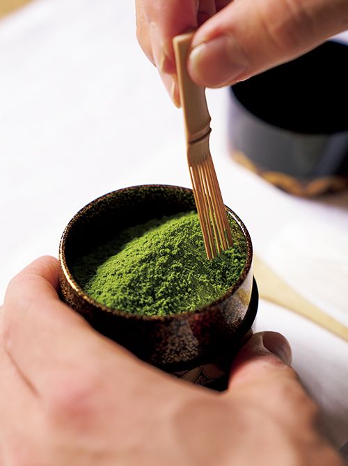 中次（なかつぎ）の茶器にお茶を掃くところ。掃き方は「一文字」と「杉形（すぎなり）」の2種類があり、茶器の形によって掃き分ける。中次の茶器は一文字に掃く。手にしているのは茶筅を加工した道具。