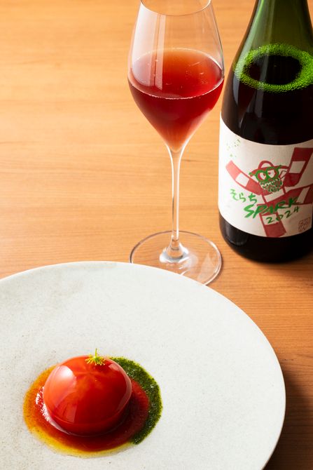 前菜「富山湾の甲殻類のコンソメで覆った信州産フルーツトマト　能生産の蟹とアボカドのサラダを詰め込んで」は、北海道・10R（トアール）ワイナリーのスパークリングワイン「そらちスパーク」とともに。 