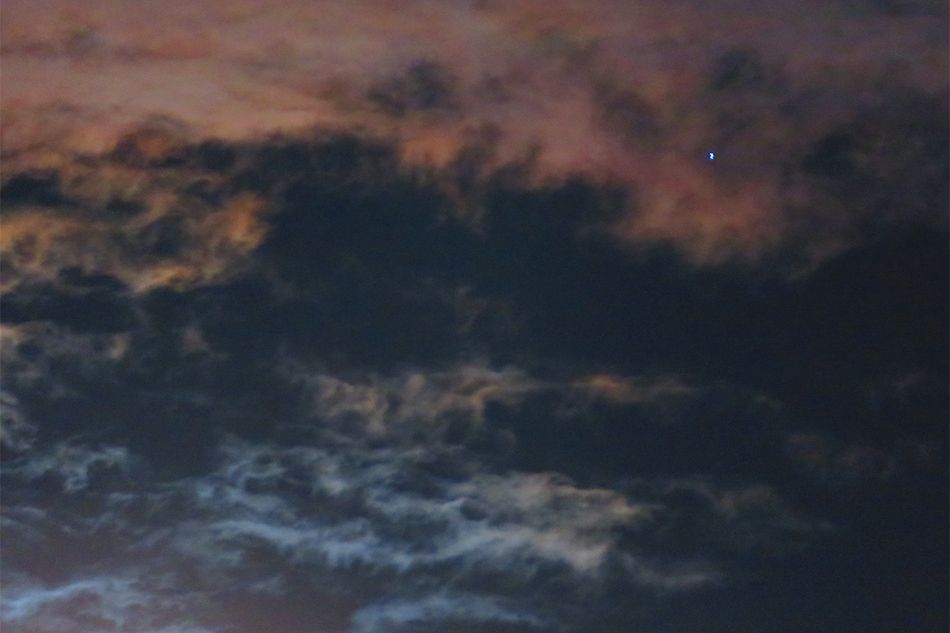 輝く月の周りに広がる淡い虹色の彩雲。月が明るい夜に探してみて