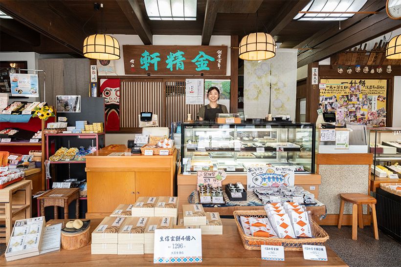 製造販売マネージャーの小野珠央さん（カウンター奥）。県を代表する銘菓「信玄餅」ほか、山梨土産にしたい和菓子が机一面に並ぶ。
