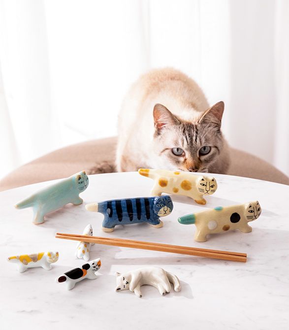 奥右から・「にっぽんのリサ猫」シリーズ（幅11×奥行き3×高さ4.5センチ）四番〈益子・あわせゆう〉、三番〈益子・あめゆう〉、十一番〈信楽・青〉、十番〈萩・夏時雨〉各6600円　中央右から・箸置き（幅6.1×奥行き2×高さ2センチ）〈マイキー・buchi cat・茶〉、〈マイキー・calico cat〉各1485円　〈波佐見焼・三毛猫・金〉（2個セット）5500円　手前・「ねむそうな猫／Clémentine de Chabaneix」（幅8.2×奥行き4.1×高さ1.5センチ）3万3000円／すべてトンカチ　©LISA LARSON　©Clémentine de Chabaneix
