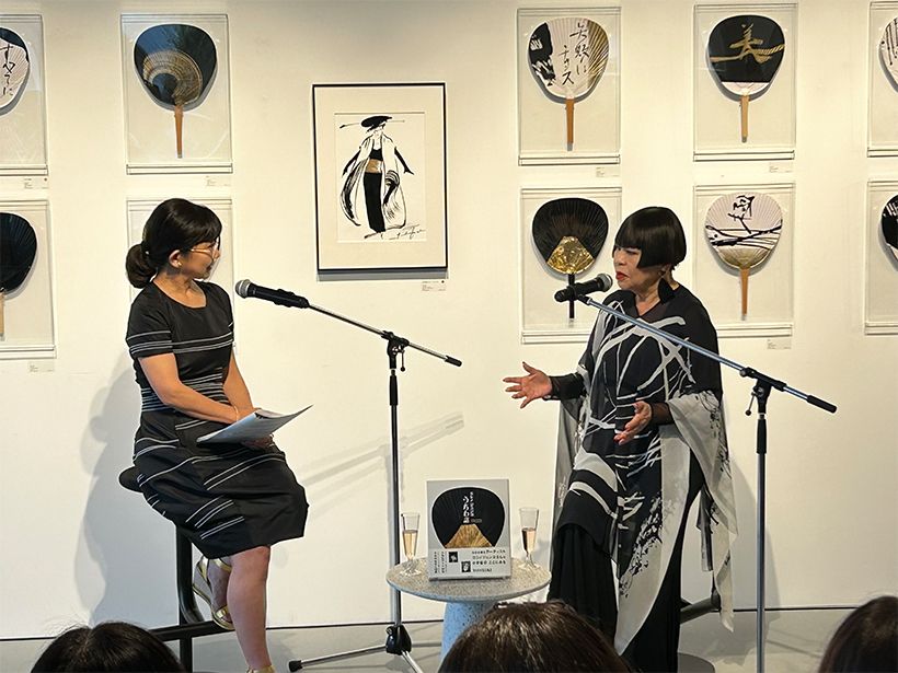 笑顔で対談するコシノジュンコ氏(右)と『家庭画報』15代目編集長、千葉由希子(左)。バックを飾るのは華やかな「うちわアート」と「モード画」。