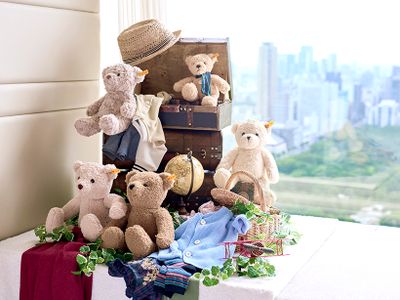 テディベアたちがスーツケースに洋服を詰めて旅支度。