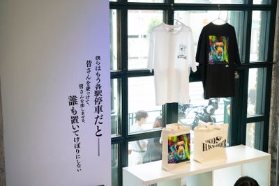 37年間の歩みと世界観を多角的に演出している本展だが、イベントグッズには小林さんの作品をモチーフにしたTシャツも。写真家・JULENさんが撮影した2023年のニューヨーク公演のライブ写真を特別に提供してもらい、小林さんがスマッジの手法で躍動感や身体性を表現。内覧会には来られなかった沖祐市さん(Keyboards)、加藤隆志さん(Guitar)、茂木欣一さん(Drums)も含めたメンバー8人が「Paradise Has No Border」を感じた瞬間を語った貴重な映像はモニターで視聴できる。