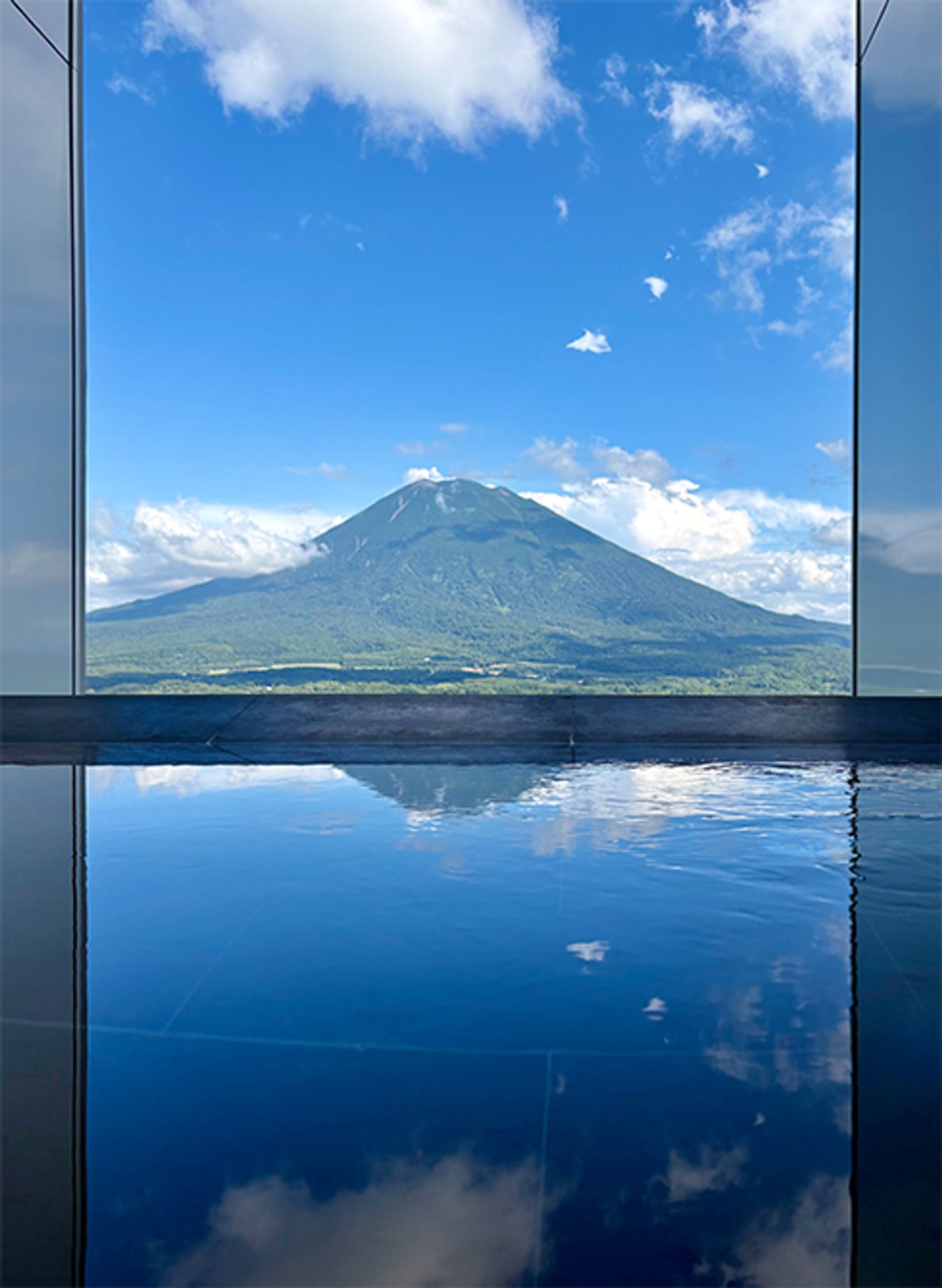 眼前に羊蹄山を望むインフィニティ温泉。豊かな緑に包まれる季節、羊蹄山は冬とはまた趣の異なる雄大な表情を見せる。