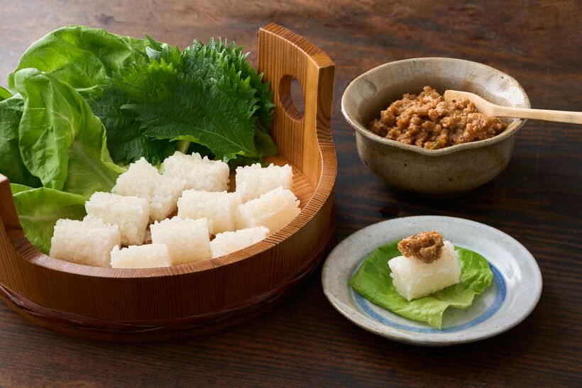 炊き立てのご飯を俵形の抜型で抜き、サラダ菜、大葉とともに盛り、肉味噌を添える。サラダ菜や大葉（一緒でも）の上にご飯をおき、肉味噌をのせて包んで食べる。