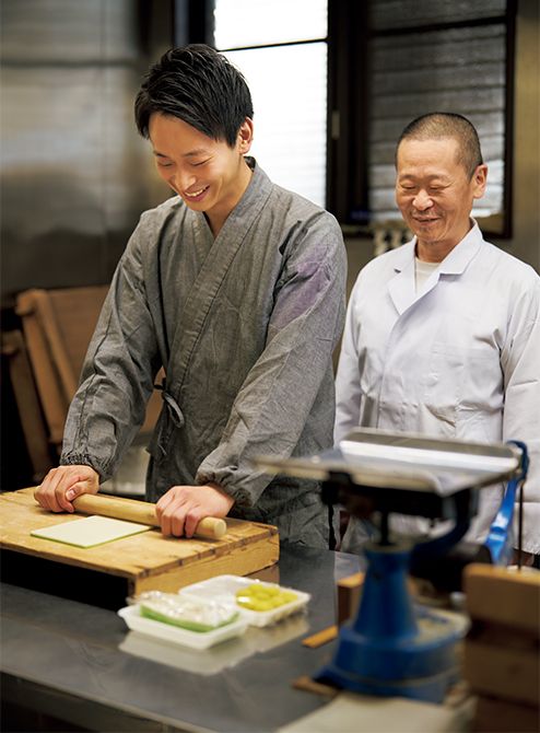 「玩月」の生地をのばす若宗匠。後ろで見守る源田恒房氏は、遠州流茶道のお菓子を長年手がける東京・大久保の茶の湯菓子處「源太萬永堂」の2代目。